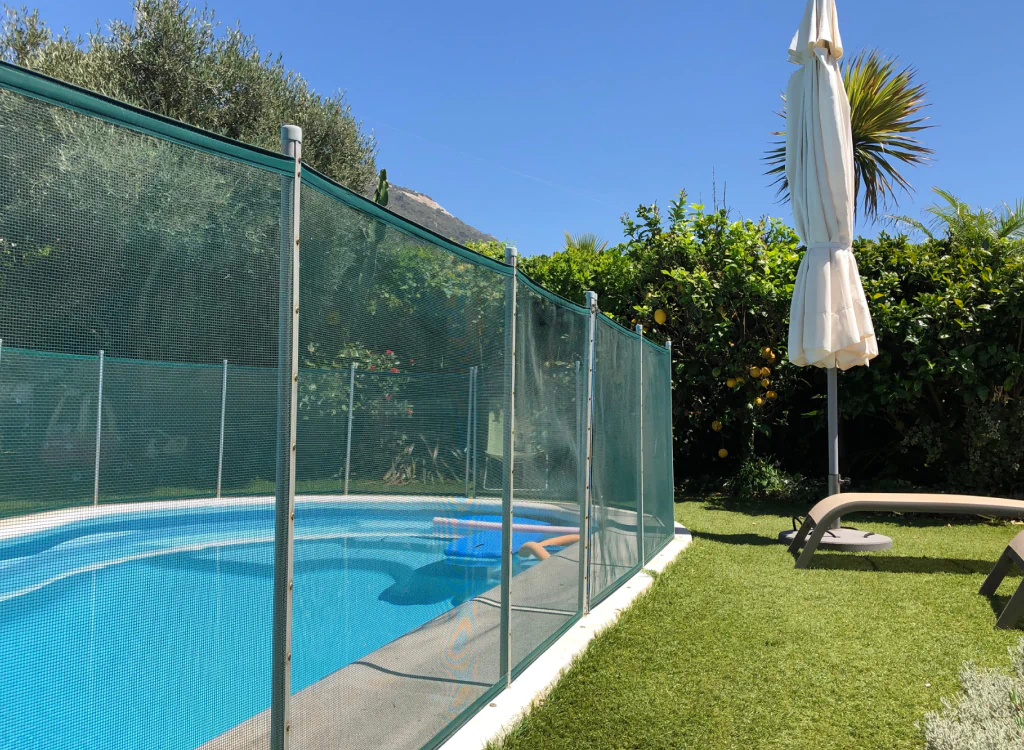 pool with a red fence and some grass around